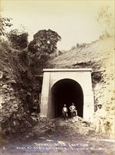 Completion of tunnel 'No. 15'. Two engineers pose amongst the rubble at the entrance to newly