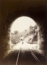 Railway tunnel, Jamaica. View from inside a railway tunnel looking out towards a man who stands on