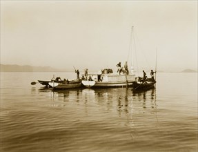 Boats on Chilka Lake. Three small boats, piloted by a team of men, float together on the calm