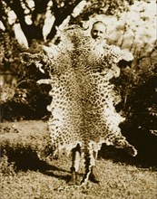 Panther skin, Bangladesh. A British man poses proudly for the camera holding an outstretched