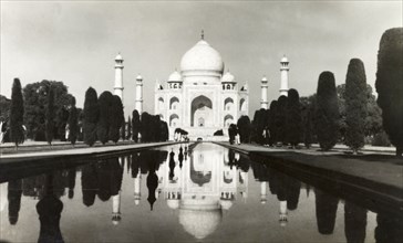 The Taj Mahal, circa 1925. View of the Taj Mahal, reflected in the central canal running up to its