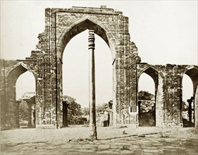 The Iron Pillar at Qutb, circa 1865. The Iron Pillar stands before the ruins of Quwwat-ul-Islam