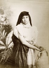 Egyptian woman. Studio portrait of a young Egyptian woman, posed in traditional dress, her hands