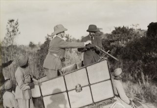 Assisting King George V. A royal aide assists King George V (r.1910-36) to load his rifle during a