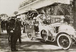 Driving to Nagpur Fort. A uniformed official closes the door of a convertible car containing King