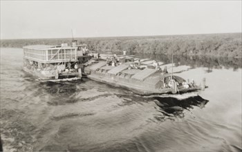 Nile steamer with barges. A steamer attended by barges makes its way along the River Nile in the