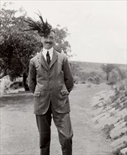 Wearing a foliage hat. A member of the Duke of Connaught's royal entourage strikes a comical pose,