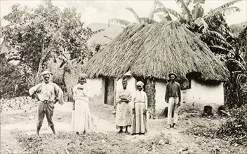 A Jamaican family. A Jamaican family pose for the camera outside a thatched roof dwelling. Jamaica,