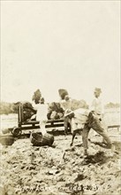 Extracting asphalt from the Pitch Lake. Labourers load lumps of asphalt extracted from Trinidad's