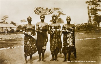 Asante swordbearers. Group portrait of four traditionally dressed Asante (Ashanti) swordbearers.