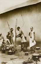 Pounding fufu. Two women prepare fufu, a staple food of West and Central Africa, by pounding the
