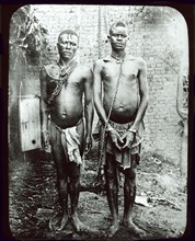 Congolese chain gang slaves. Portrait of two mannacled men, members of a chain gang enslaved under