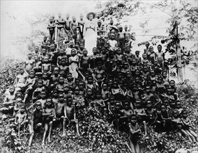 A pyramid of Congolese children. Missionary Alice Seeley Harris, dressed completely in white,