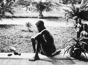 Silent despair. A Congolese man sits on a veranda, contemplating, in silent despair, the severed
