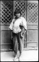 Mui tsai' child slave. Portrait of a barefooted child slave, employed as a domestic servant under