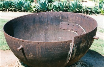 Cuban sugar cauldron. A cracked, iron sugar cauldron from Cuba, once used in the sugar refining