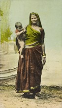 Indian woman and child. Portrait of a female Indian labourer, standing barefoot and traditionally