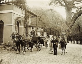 Horses at the ready. Servants wait with horses at the ready in the driveway to a large colonial