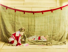 Japanese sleeping arrangements. A kneeling Japanese woman dressed in a kimono lifts the corner of a