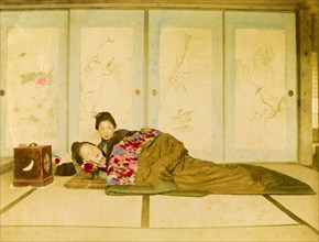 Reclining on a futon. Two Japanese women recline on a traditional futon placed on the floor. Japan,