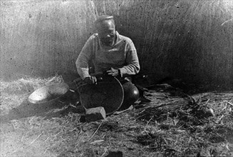 Making a reed bowl, South Africa. An elderly Zulu man sits cross-legged on the ground as he