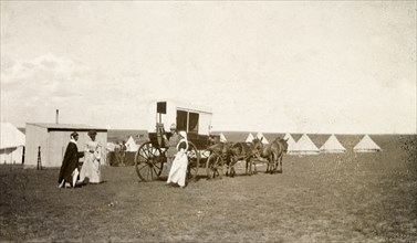 Boer War hospital camp. Two off-duty nurses prepare to board a horse-drawn coach outside a camp