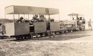 Sukkur light railway train. Two European men sit inside a stationary light railway carriage bound
