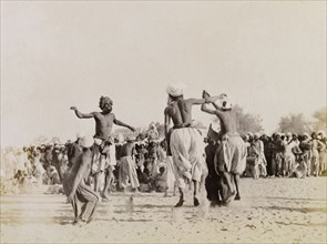Male Indian dancers. Four male dancers leap into the air as they perform in front of a large crowd