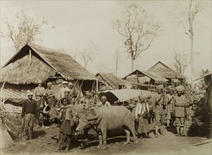 Village at the Morgandine Pass. Armed British and Indian soldiers pose beside a bullock-drawn cart