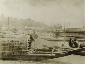 Boats on the Irrawaddy River. Several covered fishing boats are moored along a sandy bank of the