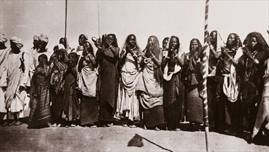 Baggara women clap their hands. A group of Baggara women stand in a line, clapping their hands in