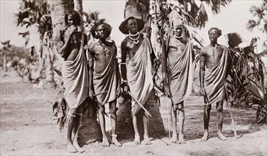 Portrait of five Shilluk warriors. Five Shilluk warriors pose for a group portrait. The men have