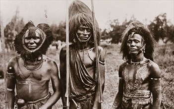 Maasai men in headdresses. Portrait of three Maasai men, two of whom are naked from the waist up