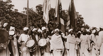Sudanese men welcome Ramadan. A group of Sudanese men, dressed in robes and turbans, bear flags and