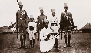 Sudanese military uniforms. Five Sudanese men and a young boy pose for the camera, wearing a