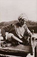 An elderly Sudanese guide. Portrait of an elderly Sudanese guide sitting cross-legged on a woven