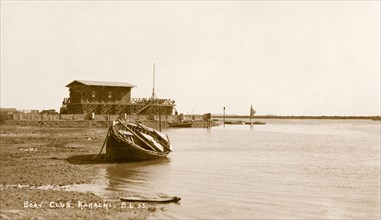 The Karachi Boat Club. A rowing boat lies on its side at China Creek in front of the Karachi Boat
