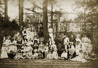 Children in historical fancy dress. A group of children pose for the camera outdoors, wearing a