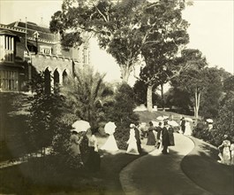 New Year's garden party at Government House, Perth. Formally dressed guests socialise in the