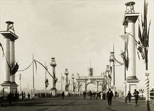 Decorations for the royal visit, Melbourne. An archway and columns are decorated with flags, part