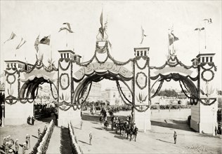 Welcome arch for the royal visit, Melbourne. A welcome arch, decorated with flags and garlands,