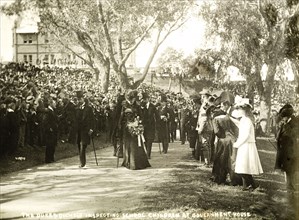 The Duke and Duchess inspect school children, Perth. Crowds of spectators watch as the Duke and