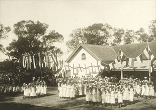 Schoolgirls perform a floral dance for the royal visit. Schoolgirls dressed in white uniforms