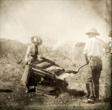 Lady Lawley operates a gold shaker. Sir Arthur Lawley, Governor of Western Australia, shovels earth