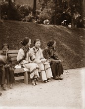 Chinese girls in a public garden in Hong Kong. Three Chinese girls, accompanied by an 'amah'