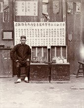 An itinerant medicine man, Hong Kong. An itenerant medicine man sits at a street stall selling
