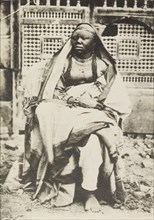 Portrait of an African woman in Egypt. Portrait of an African woman, sitting cross-legged on a
