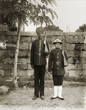 Indian and Chinese officers of the Hong Kong Police Force. Two Hong Kong police officers, one