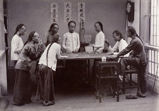 Chinese gambling game of 'fantan'. Eight men with distinctive Manchu hairstyles gather around a