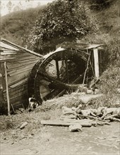 A hillside water wheel, China. A wooden water wheel is driven by a hillside stream. An original